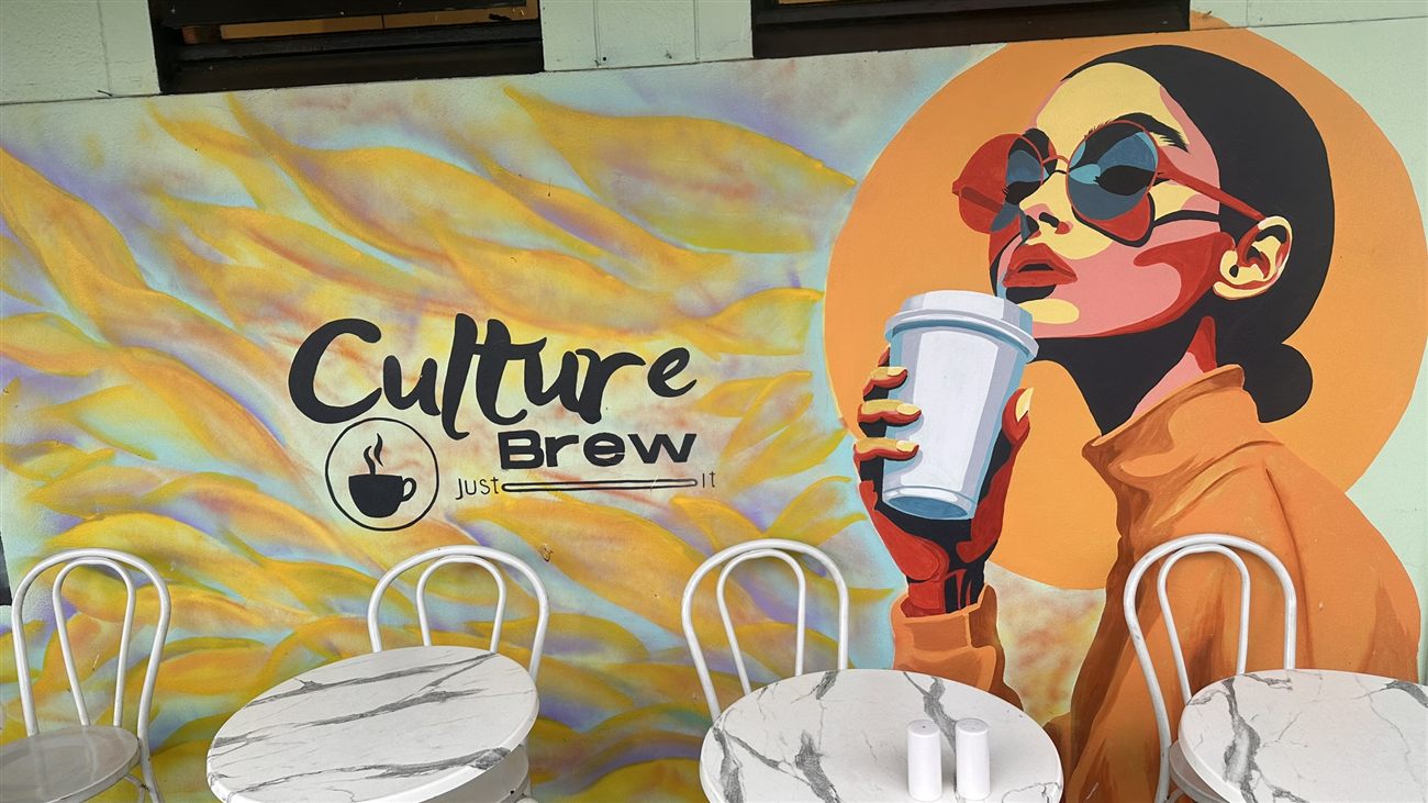 The Culture Brew 'Just Brew It' mural with marble bistro tables
